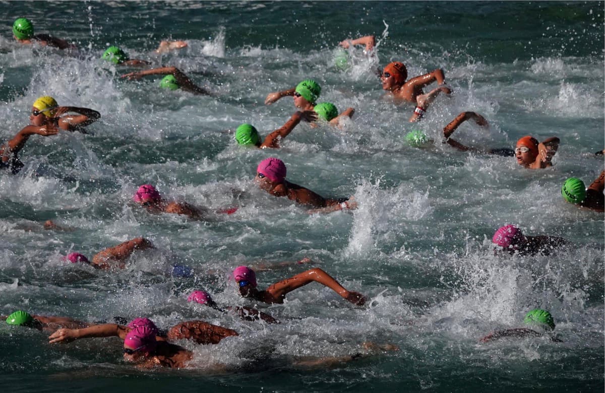 Mass ocean swim — colorful caps and splashing